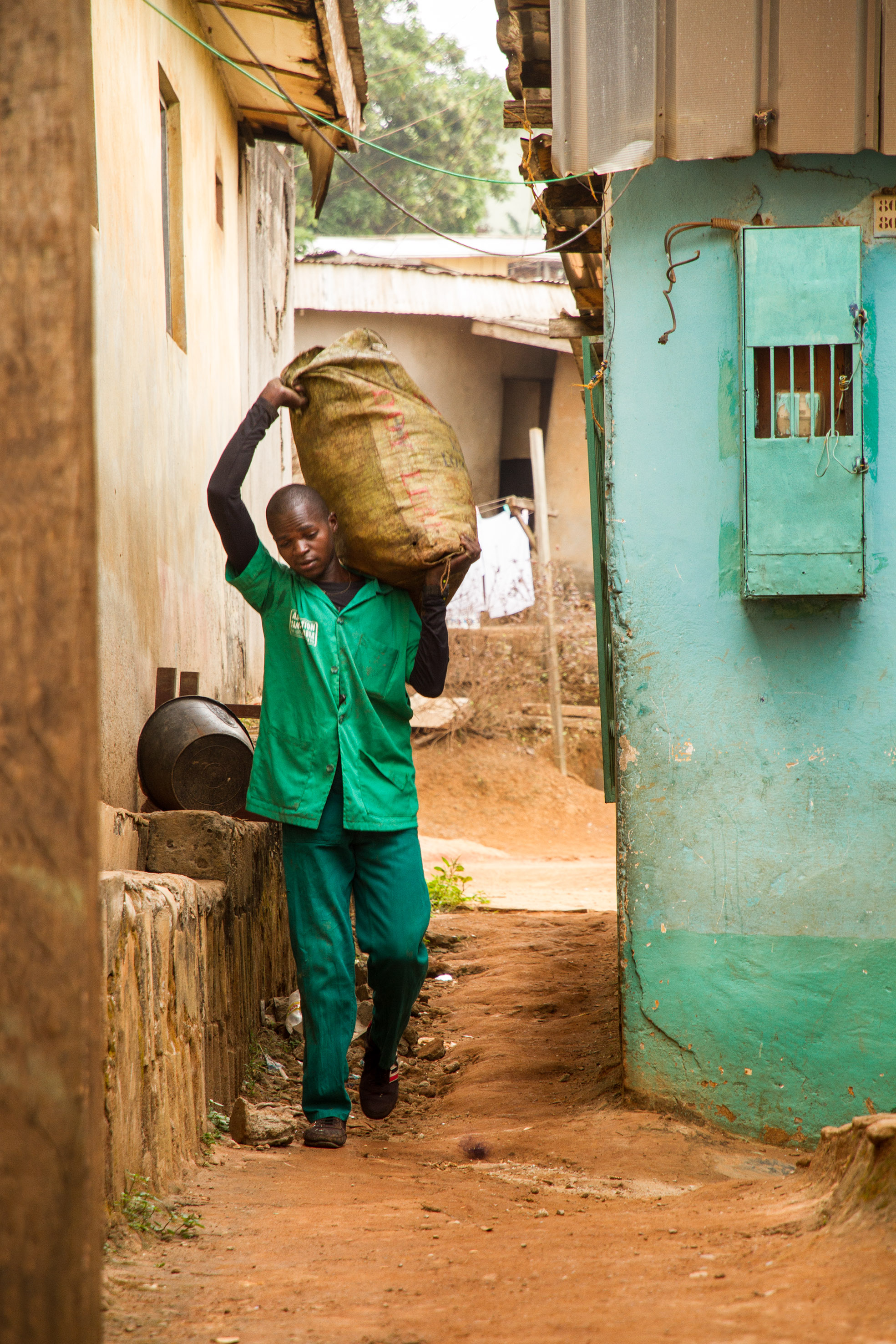 A Tam Tam mobile worker removes a bag of garbage from Melen, a slum area in the middle of Cameroon's capital Yaoundé.