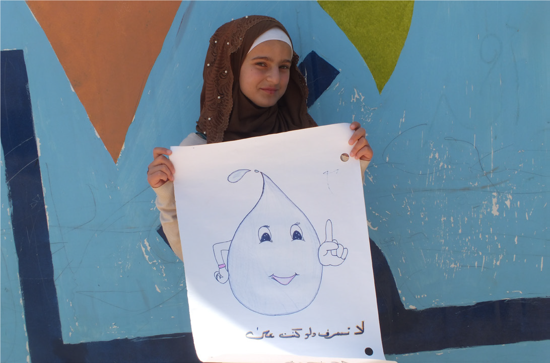 Wardeh in front of one of the Makani Centre caravans with her drawing on water conservation