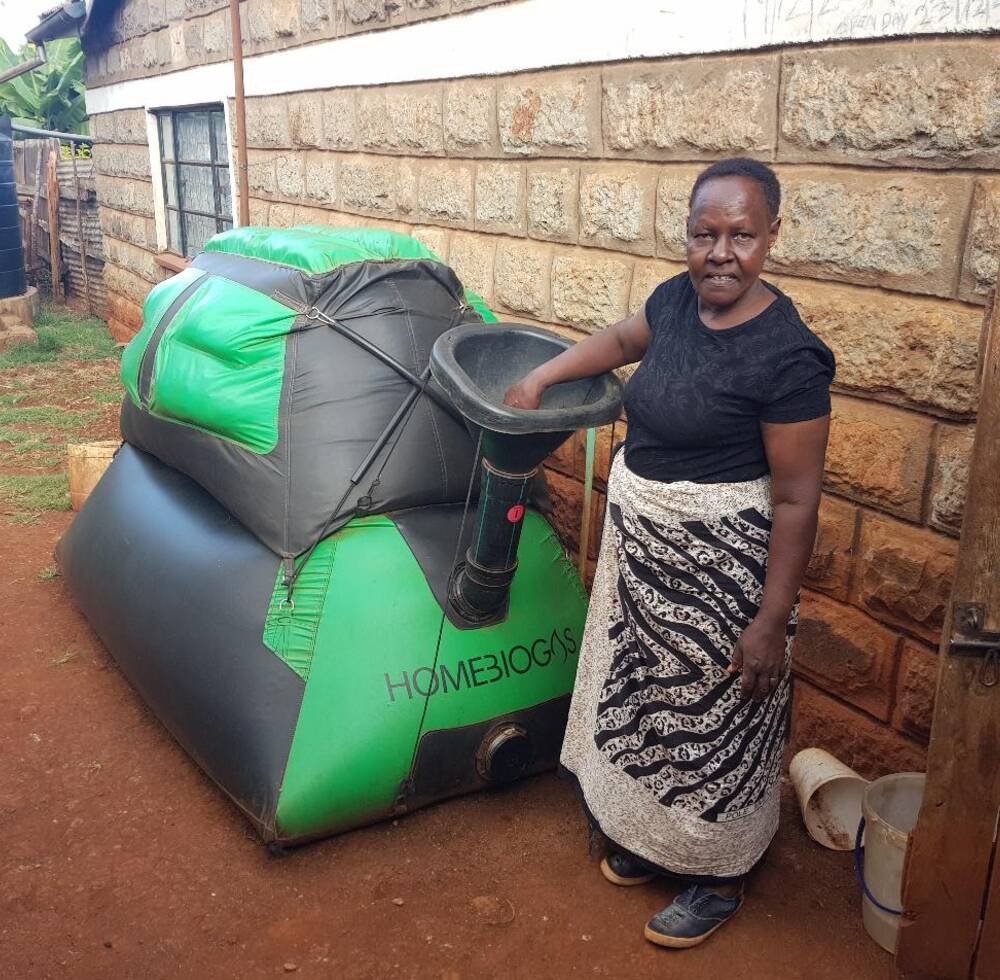 A woman uses a Homebiogas unit in her backyard